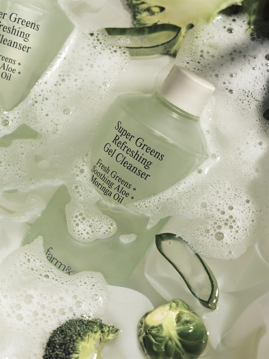 Gel cleanser in lather with greens, flat lay
